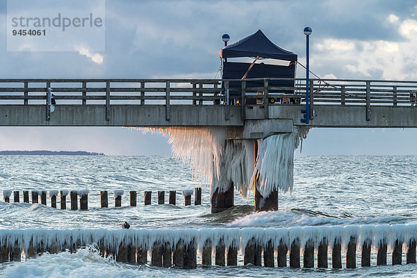 Seebrücke  mit Schnee bedeckte Wellenbrecher oder Buhnen  Eiszapfen  Abendlicht  Ostsee  Zingst  Halbinsel Fischland-Darß-Zingst  Mecklenburg-Vorpommern  Deutschland  Europa