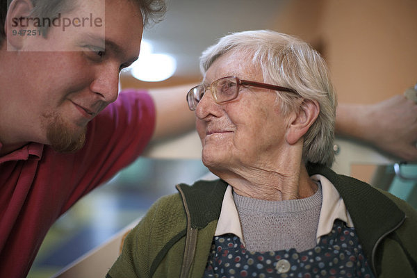 Frau  89 Jahre  im Gespräch mit einem Altenpfleger  Altersheim