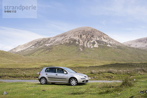Volkswagen Golf Auto neben der Straße geparkt  mit dem Berg Beinn Dearg hinten  Strathaird  Isle of Skye  Schottland  Großbritannien  Europa