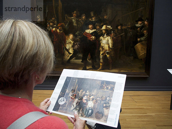 'Besucher betrachtet das Gemälde ''Die Nachtwache'' von Rembrandt im Rijksmuseum  Amsterdam  Provinz Nordholland  Holland  Niederlande  Europa'