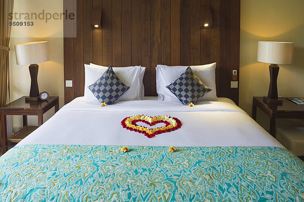 Hotelbett mit Blütenblättern geschmückt  Ubud  Bali  Indonesien  Asien
