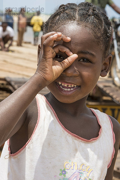 Mädchen  ca. 6 Jahre  schaut durch Finger  Belo-sur-Tsirihibina  Madagaskar  Afrika