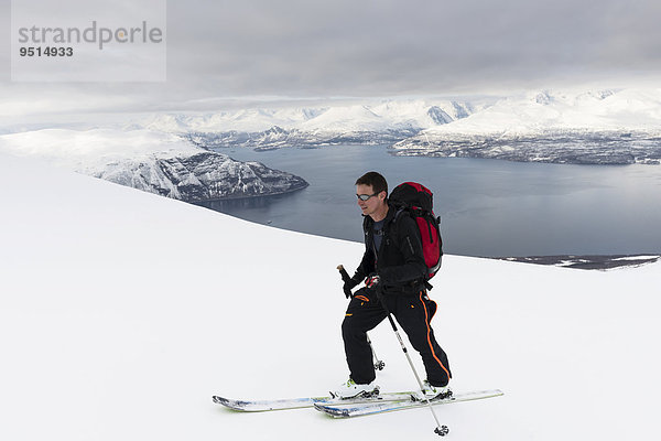 Aufstieg mit Ski zum Giilivarri  darunter der Lyngenfjord  Lyngsalpene  Lyngenalpen  Troms  Norwegen  Europa