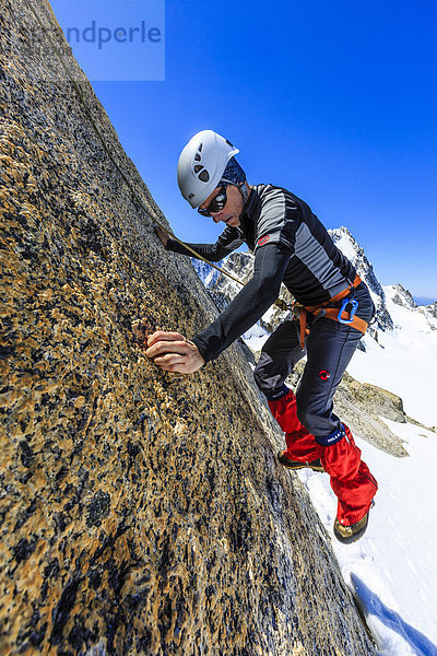 Bergsteiger klettert an einer Felswand unterhalb des Gipfels  Petite Fourche  Hochtour  Alpen  Wallis  Schweiz  Europa