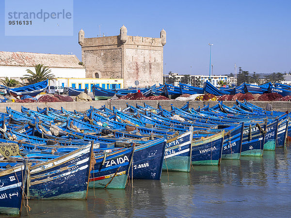 Alte blaue Fischerboote im Hafen von Essaouira  hinten die Festung von Essaouria  Unesco-Weltkulturerbe  Marokko  Afrika