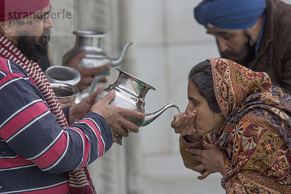 Pilger trinken geweihtes Wasser  Bangla Sahib Gurudwara Sikh Tempel  Delhi  Indien  Asien