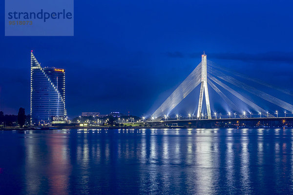 Van?u-Brücke  Zugseilbrücke  in der blauen Stunde  über den Fluss Daugave  Düna  mit dem Gebäude der Swedbank  Riga  Lettland  Europa