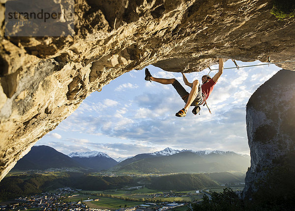 Freikletterer mit Helm klettert im Vorstieß an einer Felswand  Martinswand  Galerie  Innsbruck  Tirol  Österreich  Europa