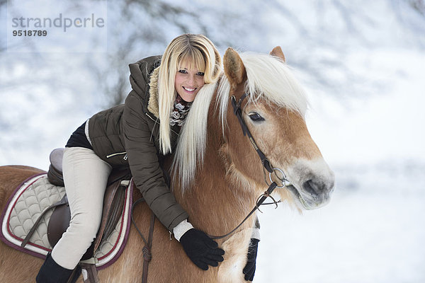 Junge Frau reitet auf einem Haflinger