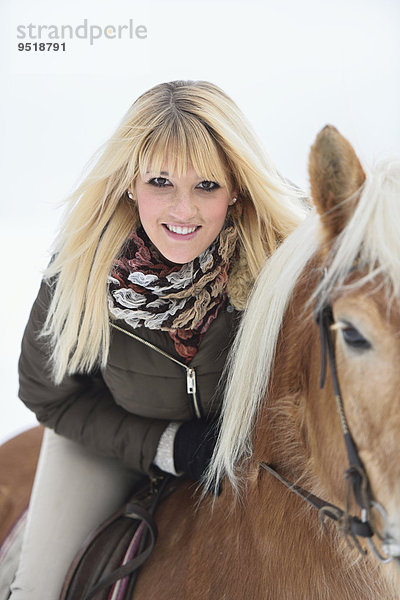 Junge Frau reitet auf einem Haflinger