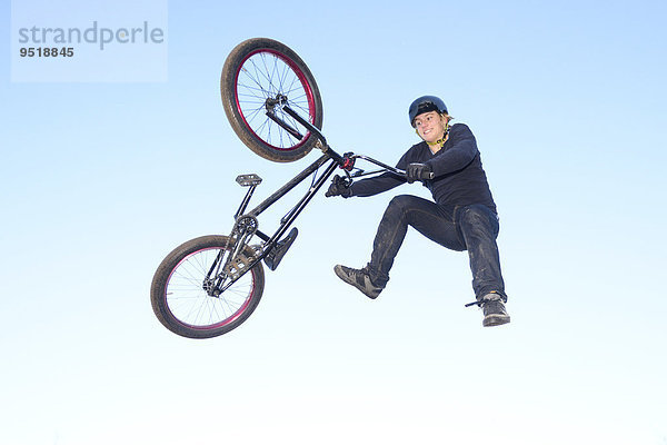 Teenager auf einem BMX-Rad springt in die Luft