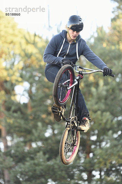 Teenager auf einem BMX-Rad springt in die Luft