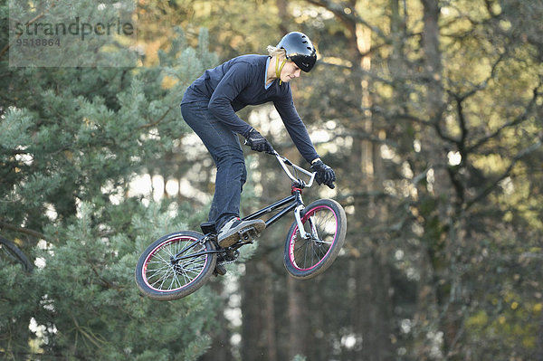 Teenager auf einem BMX-Rad springt in die Luft