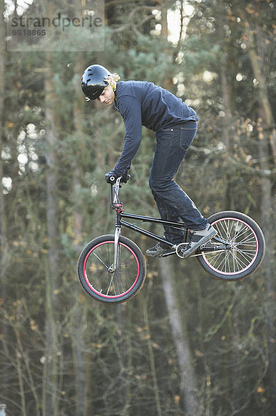 Teenager auf einem BMX-Rad springt in die Luft