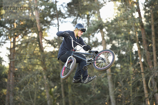 Teenager auf einem BMX-Rad springt in die Luft