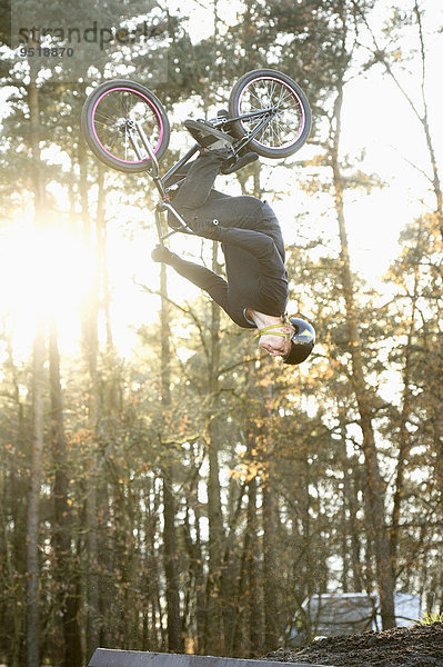 Teenager auf einem BMX-Rad springt in die Luft