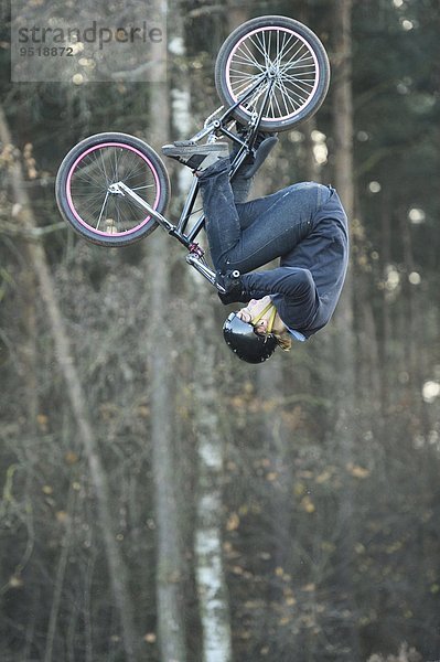 Teenager auf einem BMX-Rad springt in die Luft