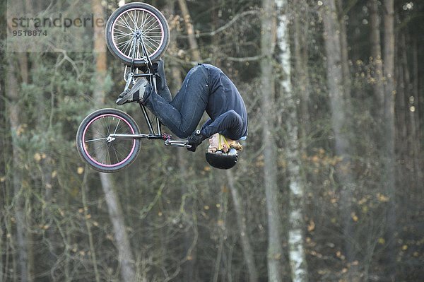 Teenager auf einem BMX-Rad springt in die Luft