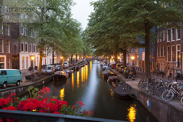 Niederlande  Amsterdam  Blick auf Reihen alter Wohnhäuser am Stadtkanal bei Abenddämmerung