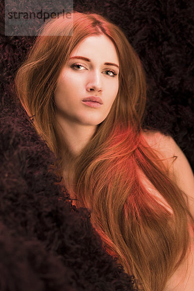 Porträt einer verführerischen jungen Frau mit langen roten Haaren