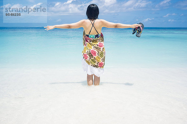 Malediven  Ari Atoll  junge Frau im Wasser am Meer stehend