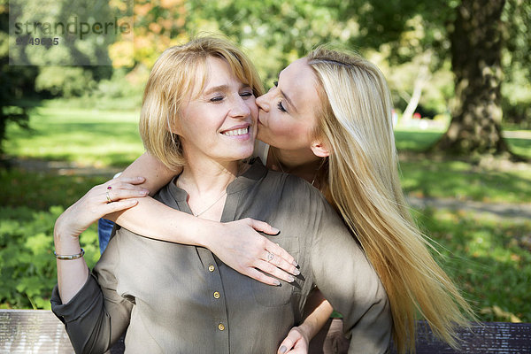 Erwachsene Tochter küssend Mutter im Park