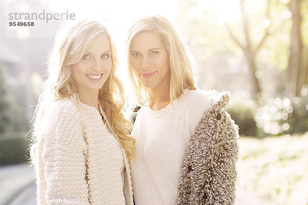 Portrait von zwei lächelnden blonden Frauen im Gegenlicht