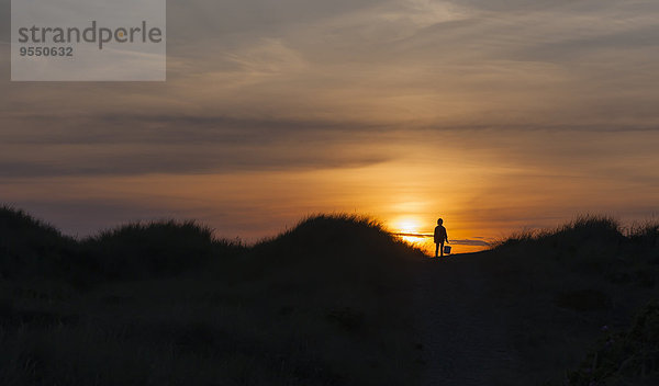 Dänemark  Jütland  Lokken  Mädchen in Düne bei Sonnenuntergang