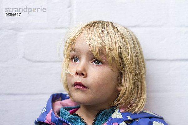 Porträt des traurigen Mädchens vor der Wand