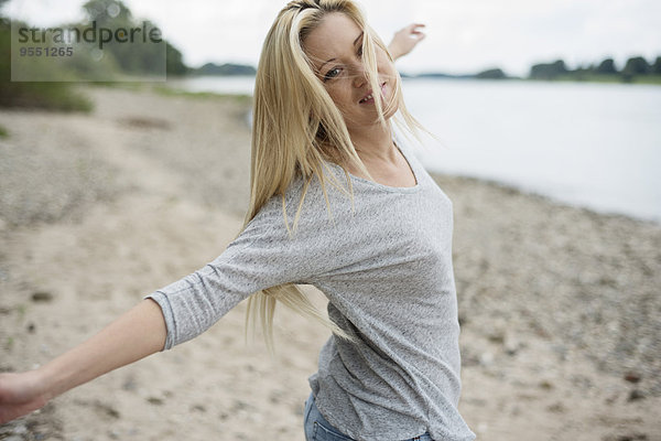 Junge Frau tanzt am Strand