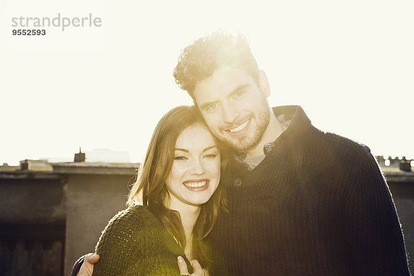 Portrait eines glücklichen jungen Paares im Gegenlicht