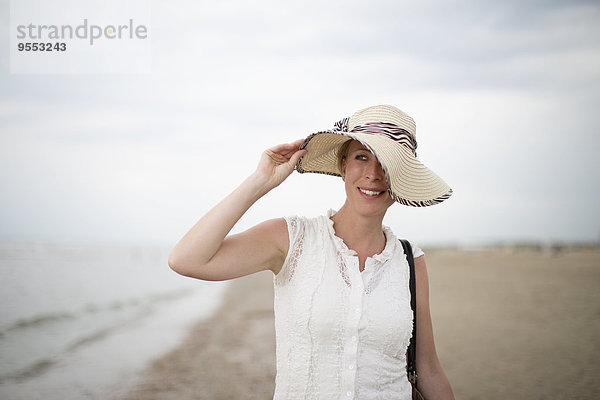 Niederlande  Noordwijk  lächelnde Frau mit Strohhut am Strand