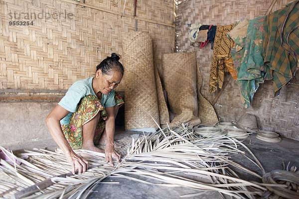 Indonesien  Lombok  Frau arbeitet in ihrer Hütte