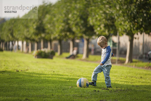 Junge spielt Fußball auf der Wiese