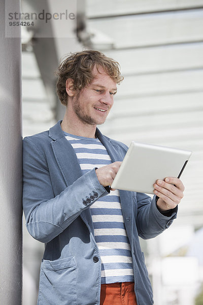 Porträt eines lächelnden Mannes mit digitalem Tablett