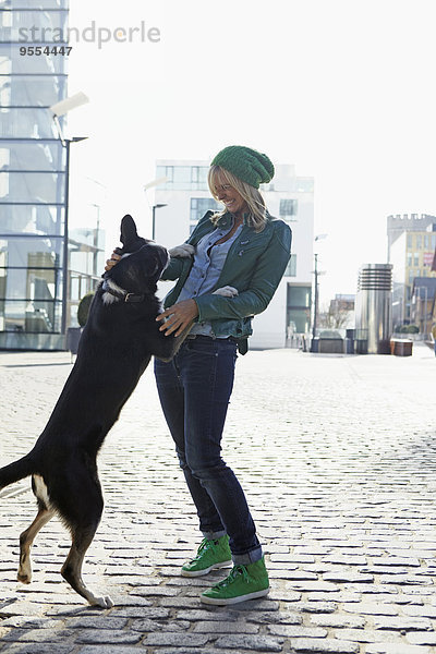 Junge Frau spielt mit ihrem Hund