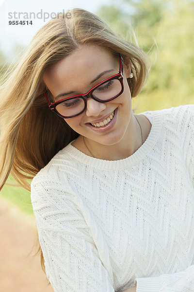 Porträt eines lächelnden blonden Teenagermädchens mit Brille