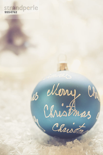 Blaue Weihnachtskugel mit den Worten'Merry Christmas'.