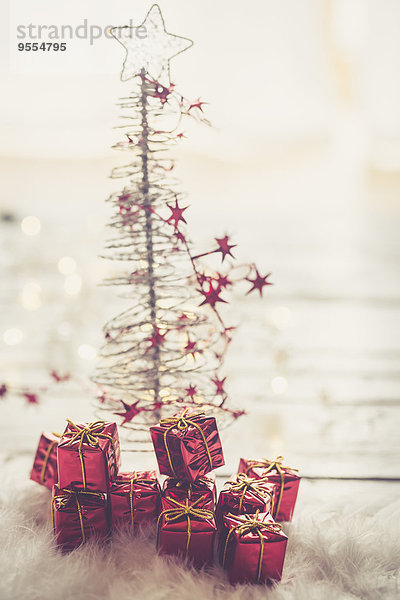 Miniatur Weihnachtsbaum mit kleinen roten Weihnachtsgeschenkboxen