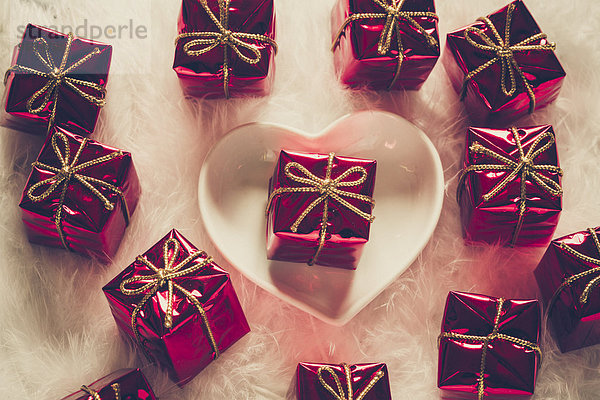 Herzförmige Schale und kleine rote Weihnachtsgeschenkboxen