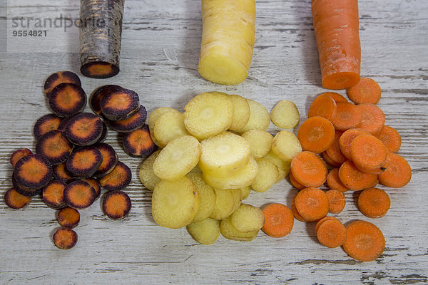 Verschiedene geschnittene Bio-Karotten auf Holz