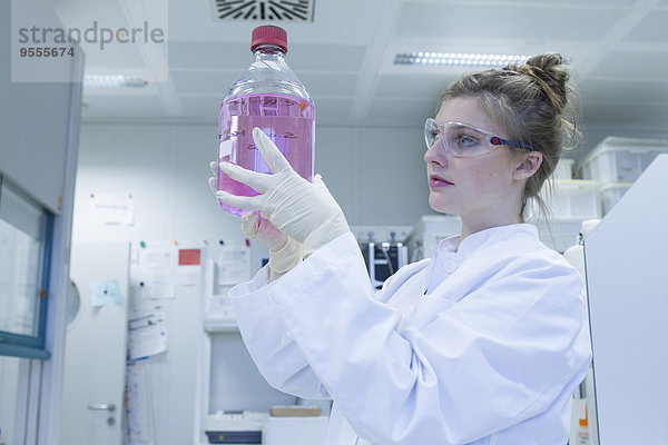 Biologe im Labor mit Blick auf die Kulturflasche