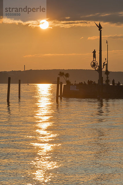 Deutschland  Baden-Württemberg  Bodensee  Meersburg  Hafeneinfahrt mit Skulptur Zaubersäule bei Sonnenuntergang