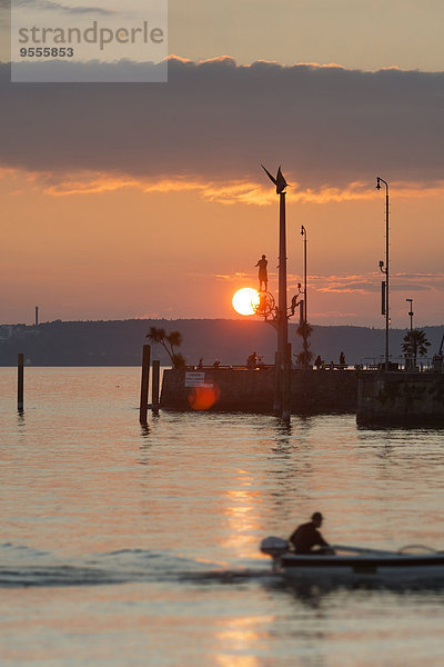 Deutschland  Baden-Württemberg  Bodensee  Meersburg  Hafeneinfahrt mit Skulptur Zaubersäule bei Sonnenuntergang