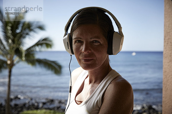 USA  Hawaii  Portrait einer Frau mit Kopfhörer vor dem Meer