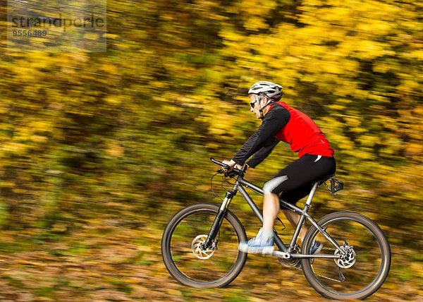 Mann auf dem Mountainbike im Herbstwald