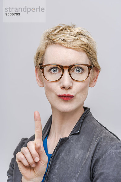 Porträt einer blonden Frau mit wedelndem Zeigefinger