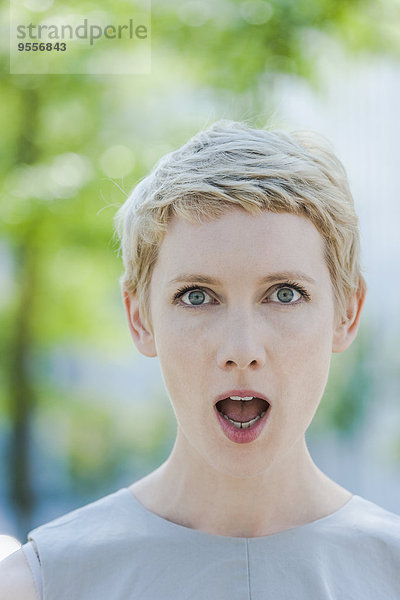 Porträt einer erstaunten blonden Frau mit geöffnetem Mund