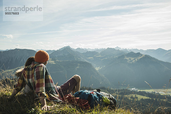 Österreich  Tirol  Tannheimer Tal  junges Paar beim Ausruhen in den Bergen