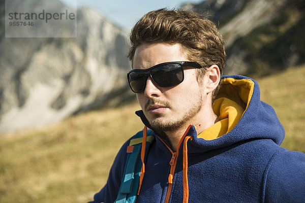 Österreich  Tirol  Tannheimer Tal  junger Mann mit Sonnenbrille